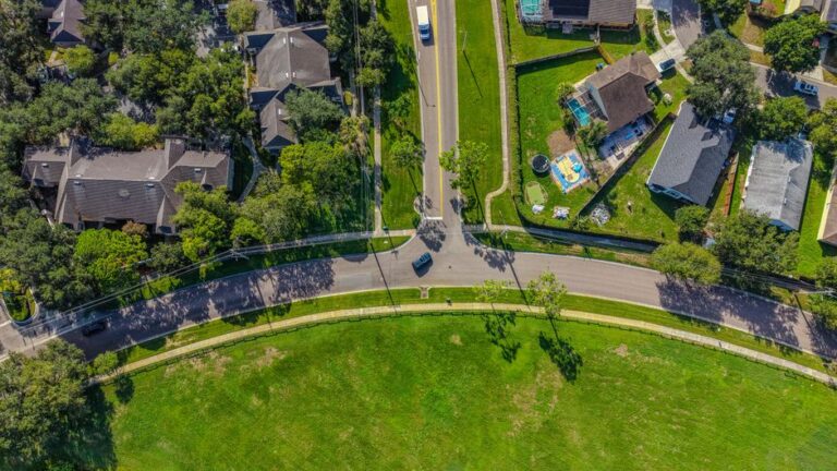 Aerial shot of a suburban neighborhood in Florida, showcasing roads, homes, and greenery.