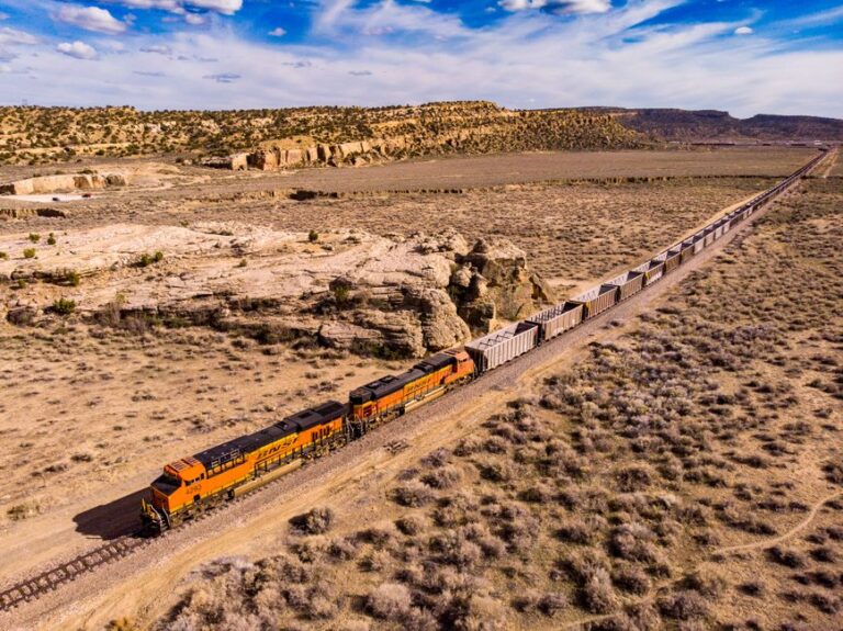Drone shot of a freight train traversing the arid desert landscape near Gallup, New Mexico.