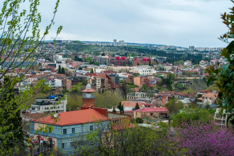 Explore the stunning urban landscape of Tbilisi, Georgia with lush greenery and traditional architecture.