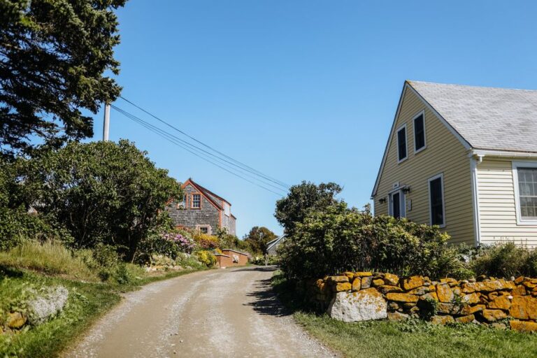 Picturesque rural road flanked by traditional New England homes on a sunny day in Monhegan, Maine.