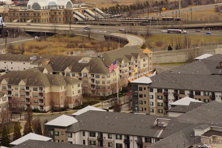 Aerial view of urban residential apartments featuring an American flag, depicting city life.